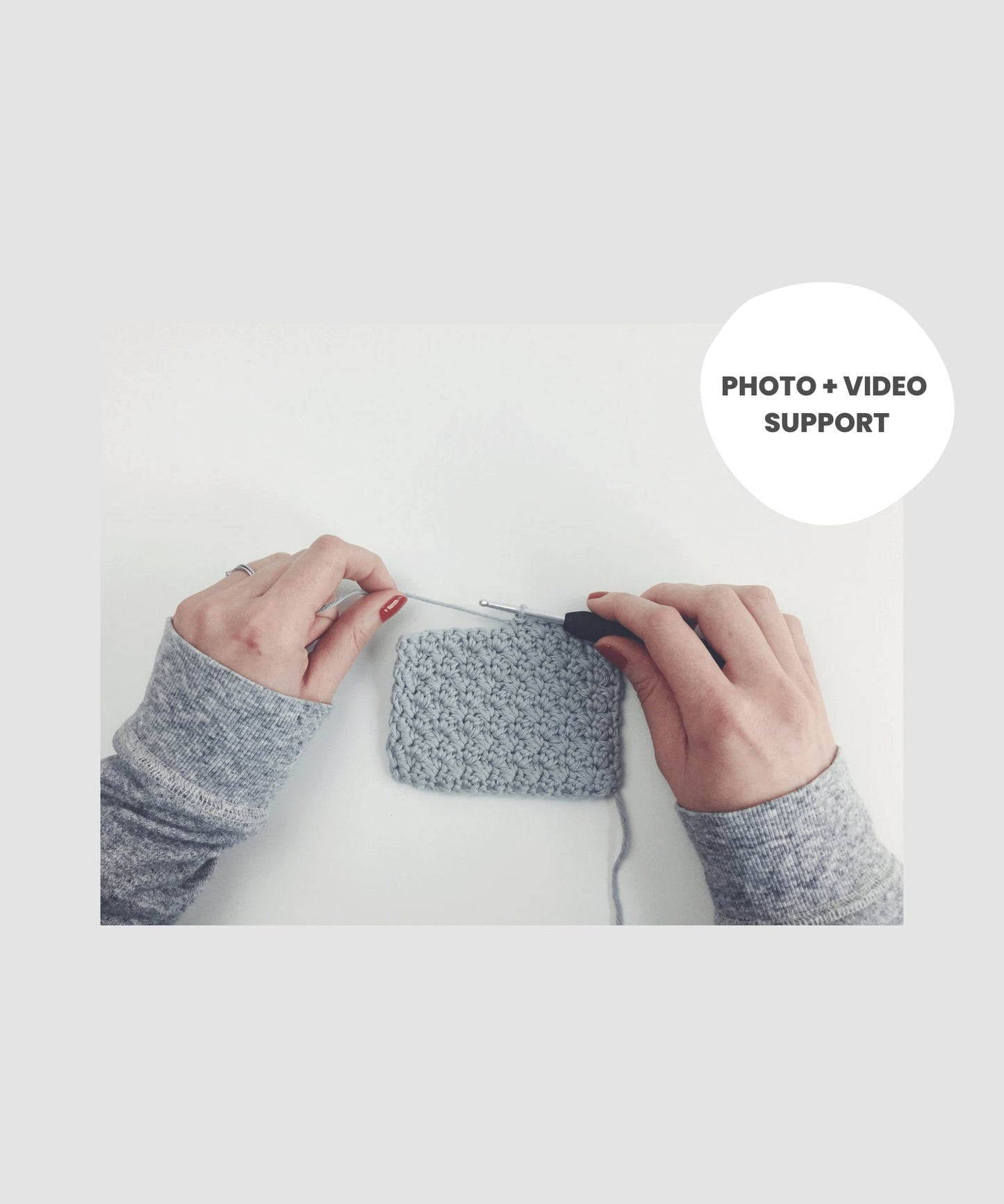 White hands with red nails are halfway through making a crochet coaster in grey cotton yarn. Text reads "Photo + Video Support".